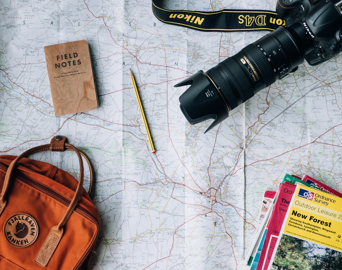 Editorial travel flat-lay — map, camera and notebook ready to pack